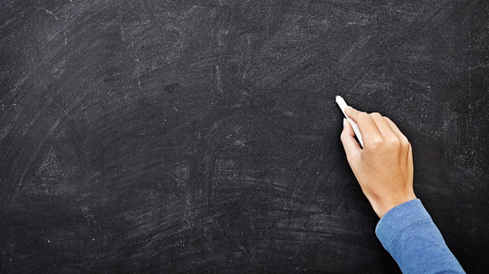 手拿粉笔在黑板写字PPT背景图片